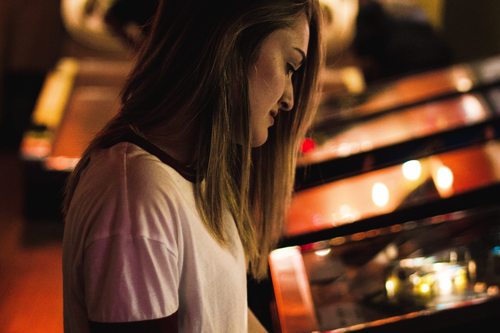 Joueuse devant une borne d'arcade dans un bar